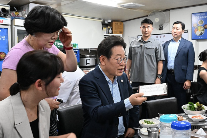  이재명 대통령이 11일 서울 광화문 인근 한식당에서 음식을 주문하고 있다. '민생회복 소비쿠폰' 지급을 앞두고 내수 경기 활성화를 위해 진행한 행사로 '대통령과 외식합니다' 제목 아래 '골목경제 살리는 한 끼!'라는 부제가 붙었다. / 연합뉴스