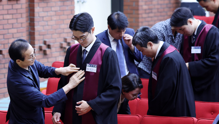 1일 경기 과천 정부과천청사 법무부에서 열린 신임검사 임관식에서 부모님들이 신임 검사들에게 법복을 입혀주고 있다. / 뉴스1