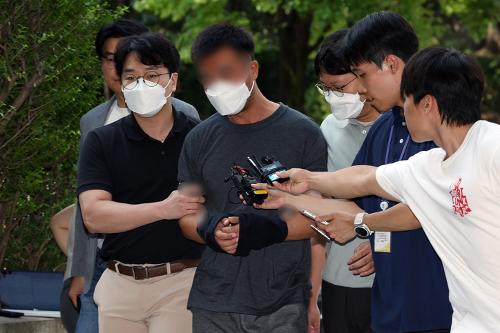 웹사이트를 해킹해 380억 원 이상을 가로챈 해킹 범죄 조직 총책인 중국 국적 남성 A 씨가 24일 오후 서울 서초동 서울중앙지방법원으로 향하고 있다. / 뉴스1