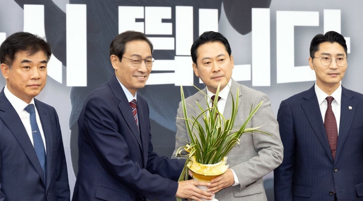 장동혁 국민의힘 신임 당대표가 27일 오후 서울 여의도 국회에서 우상호 대통령실 정무수석으로부터 축하난을 받고 있다. 2025.8.27/뉴스1 © News1