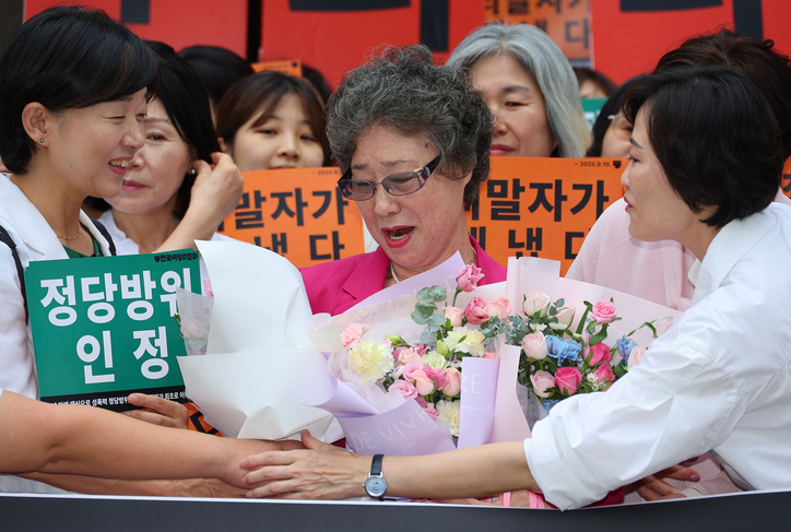 성폭행하려던 남성의 혀를 깨물어 중상해 혐의로 기소돼 유죄 판결을 받았던 최말자 씨가 10일 부산지법에서 열린 재심 선고 공판을 마친 뒤 꽃다발을 받고 있다. 최씨는 61년 만에 열린 재심에서 무죄를 선고받았다. / 연합뉴스
