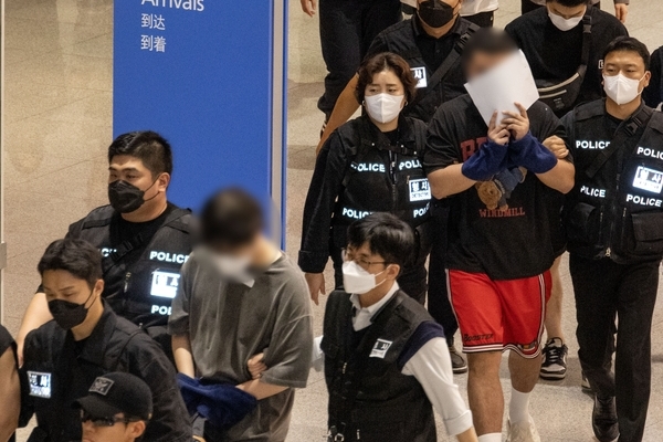 캄보디아 온라인 사기에 가담해 구금된 한국인들이 지난 18일 오전 인천국제공항 제2터미널을 통해 송환되고 있다. 이날 송환에는 경찰 호송조 190여명이 투입됐다. /연합뉴스